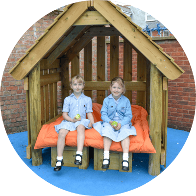 two children eating their snacks in a den