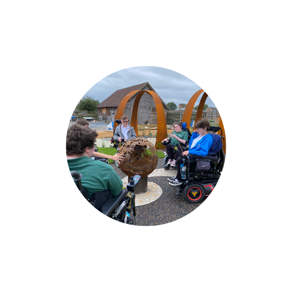 students in wheelchairs gathered in a playground