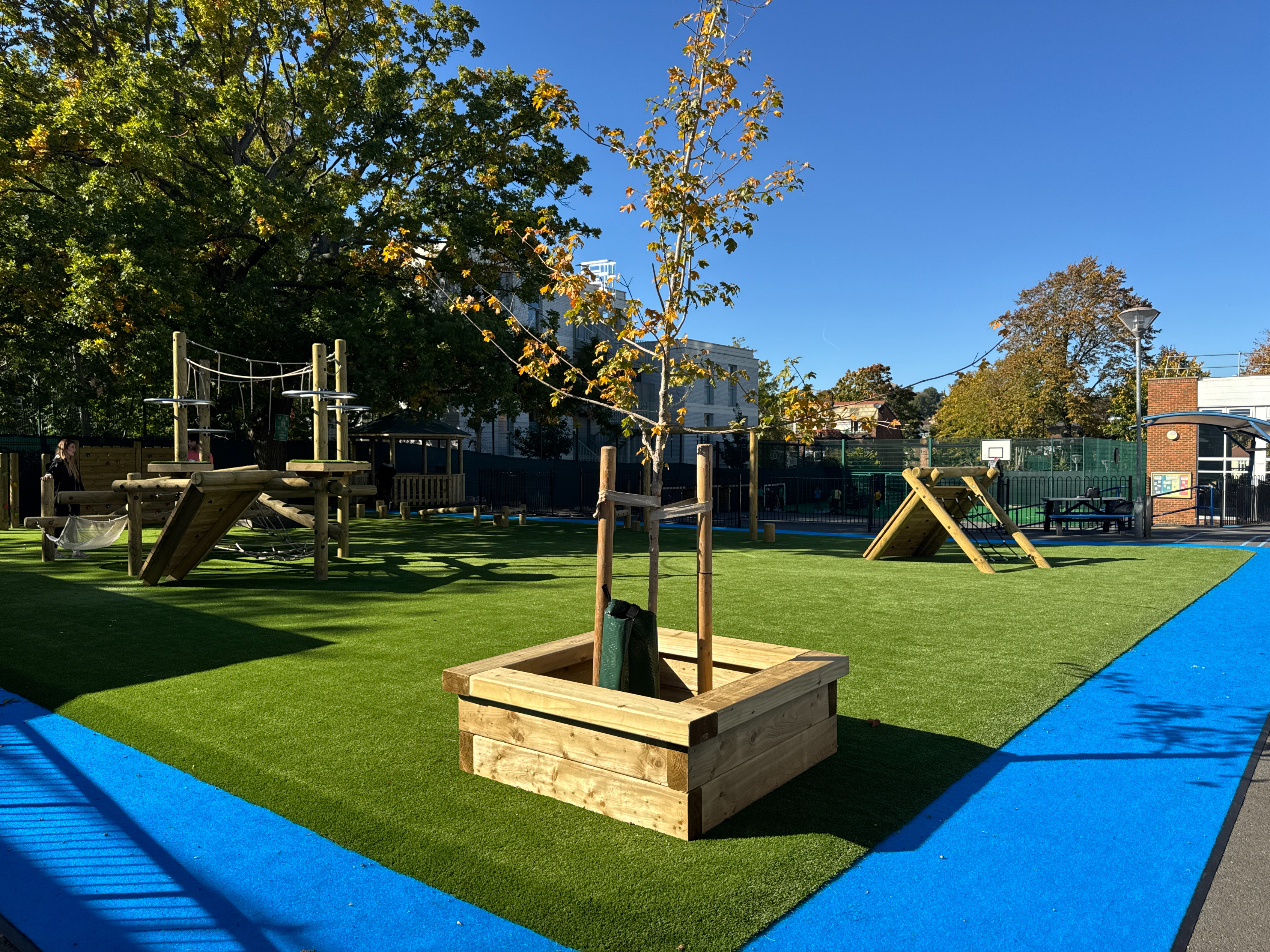 Blue Play Carpet surrounding school play equipment installation