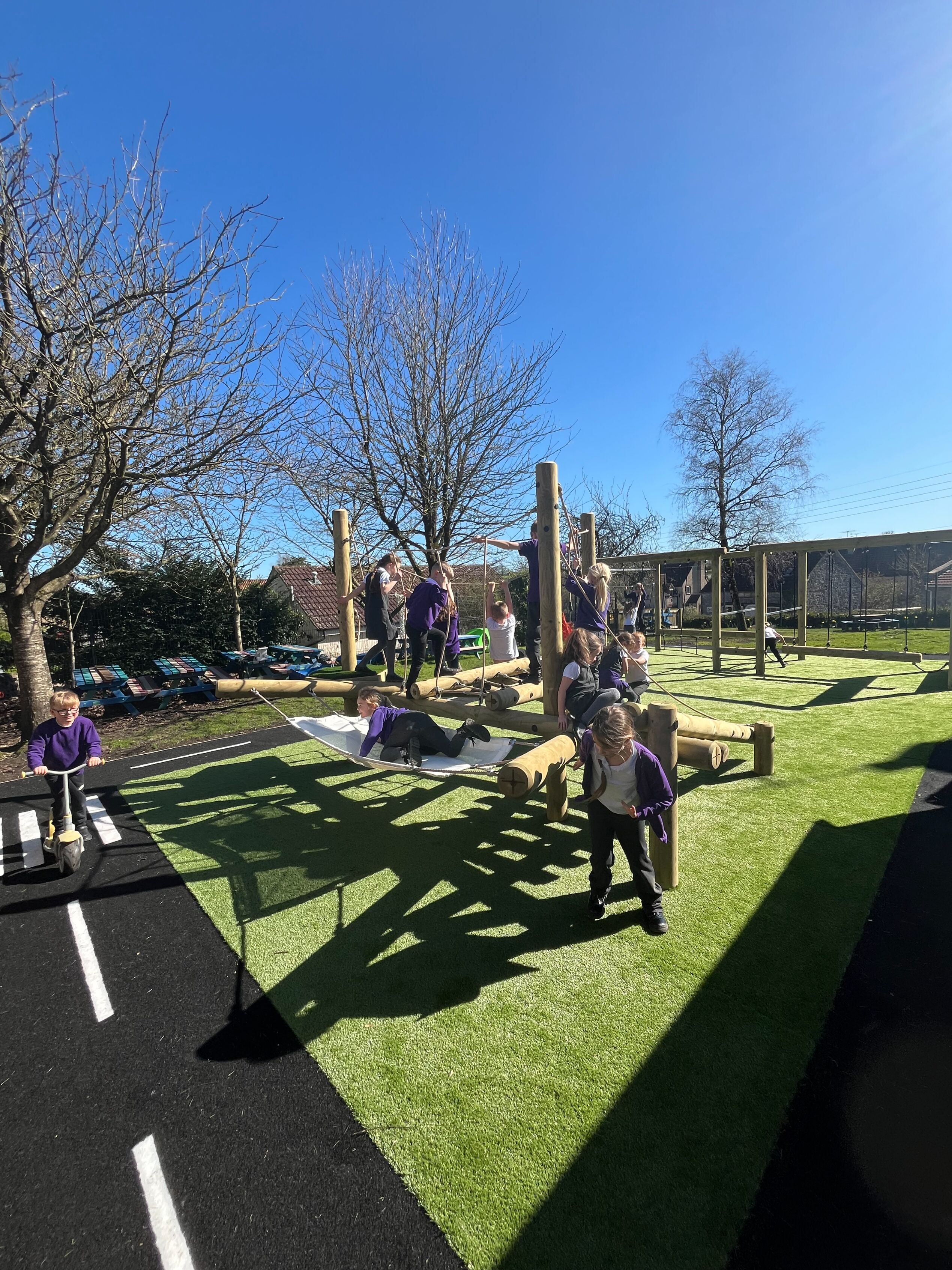 School playground design of a Willow Climber with children playing, and surrounding roadway