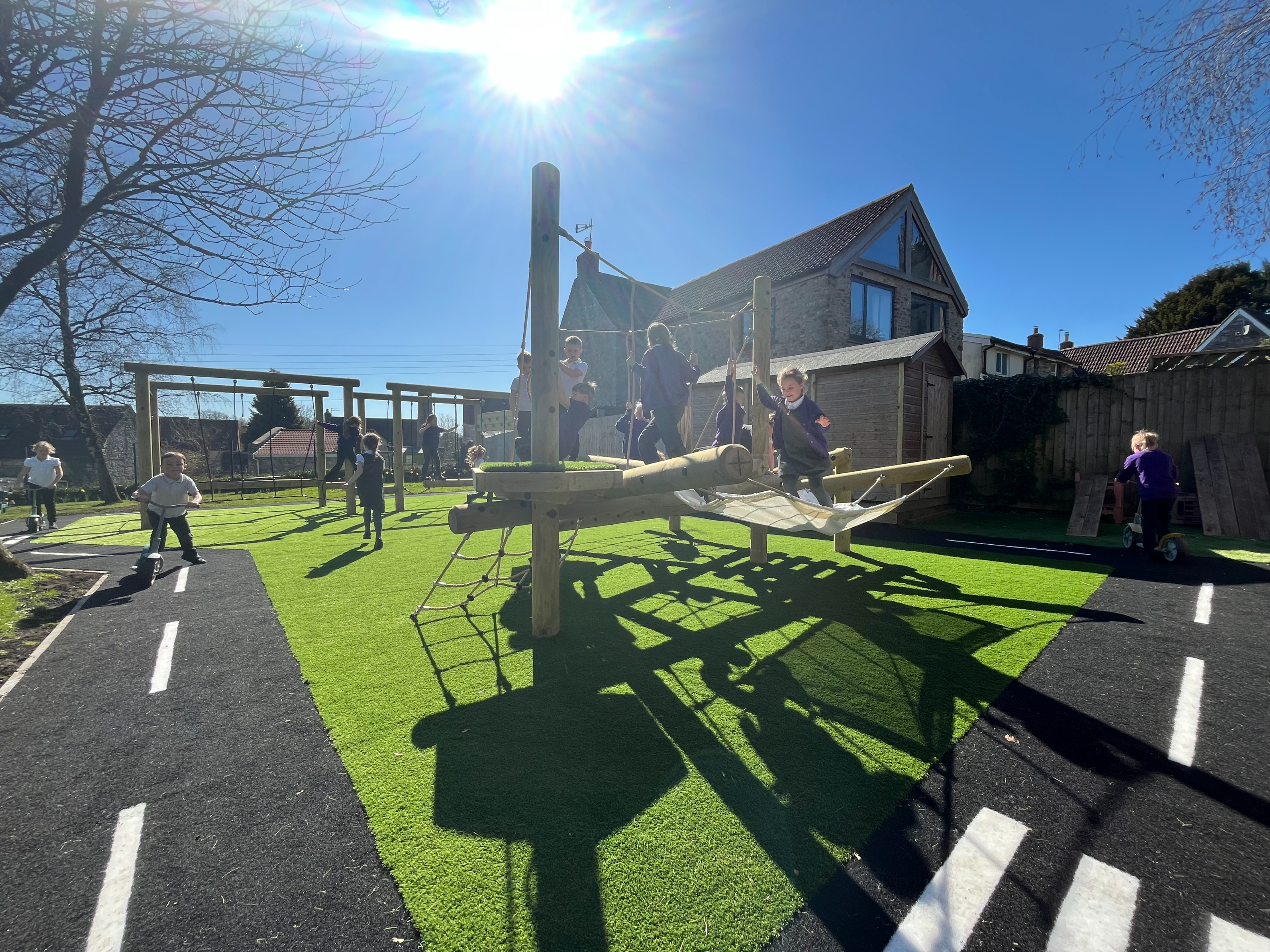 School Playground Development showing children playing on a roadway and climbing equipment - Leigh on Mendip School