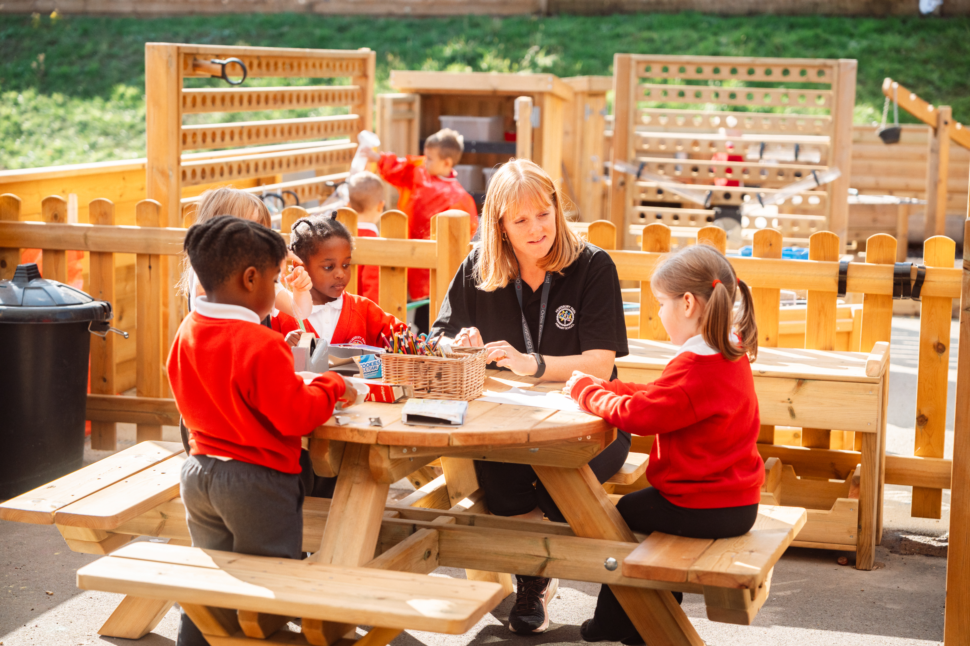 Children enjoying an outdoor learning experience with their teacher
